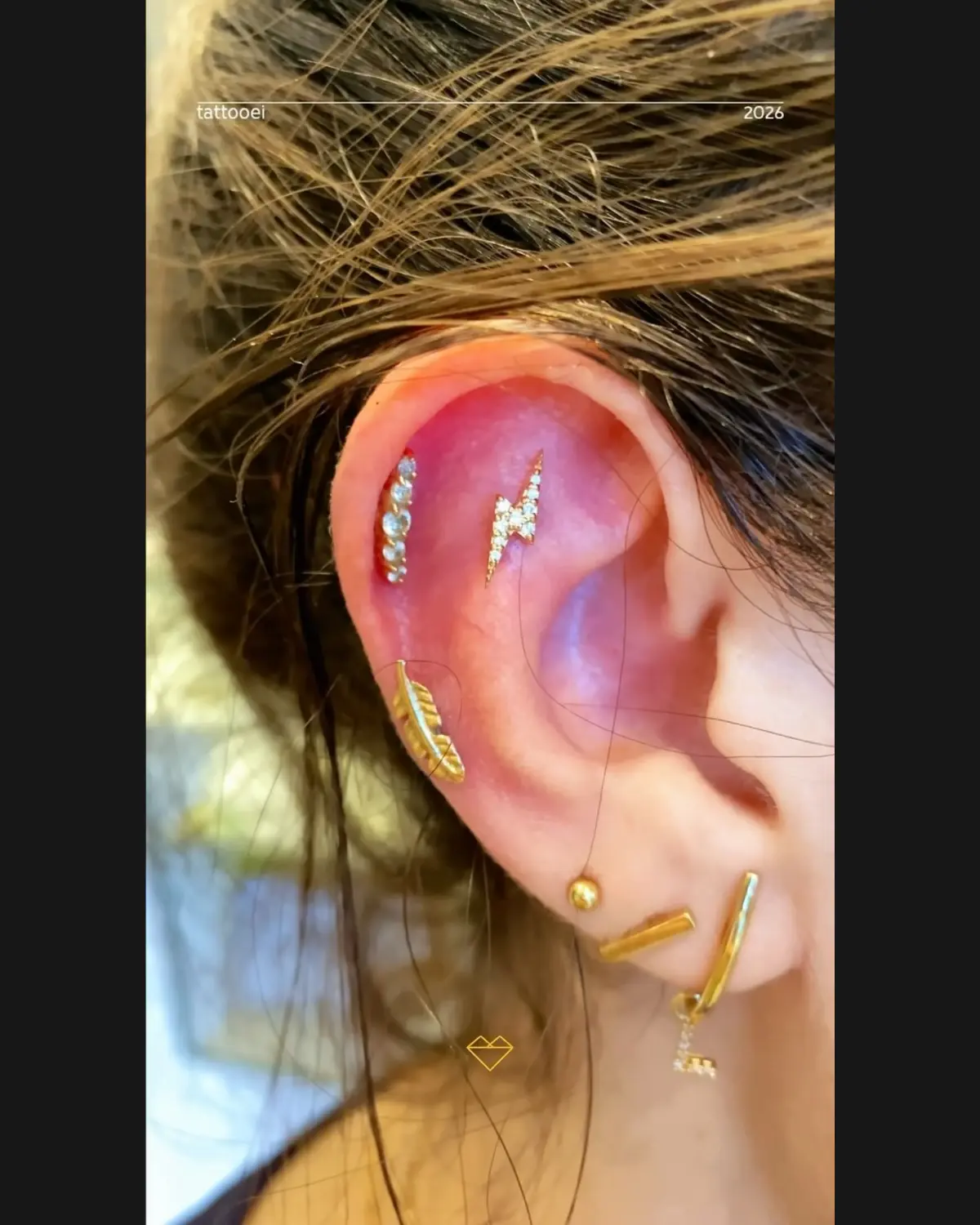 Composição de piercings com joias douradas