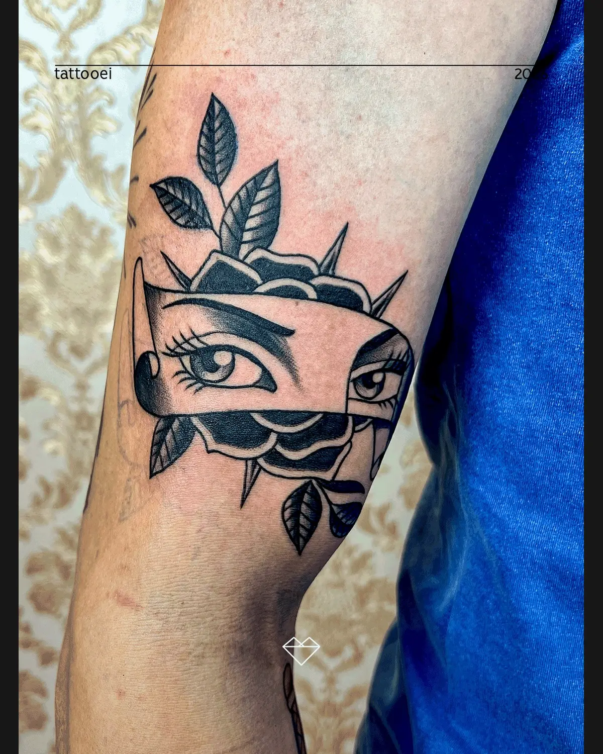 Tatuagem gráfica com olho e folhas