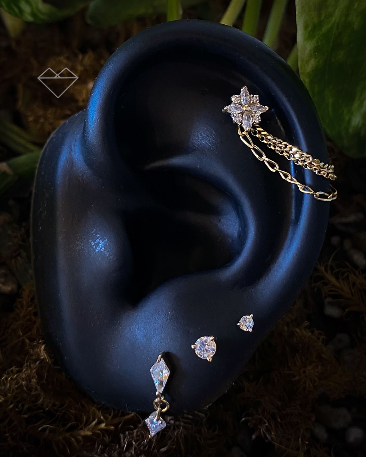 Orelha com constelação de piercings em ouro